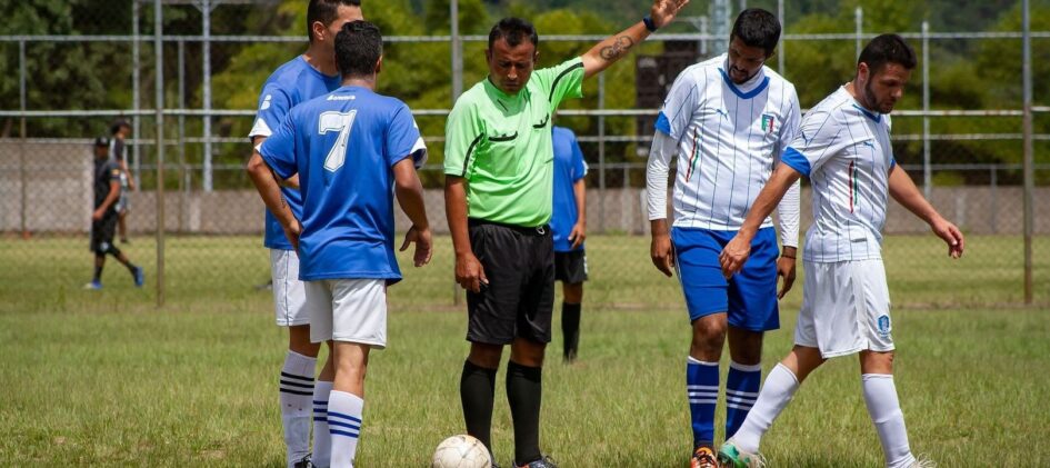 Schiedsrichter zeigt auf einem Fußballplatz eine Entscheidung an