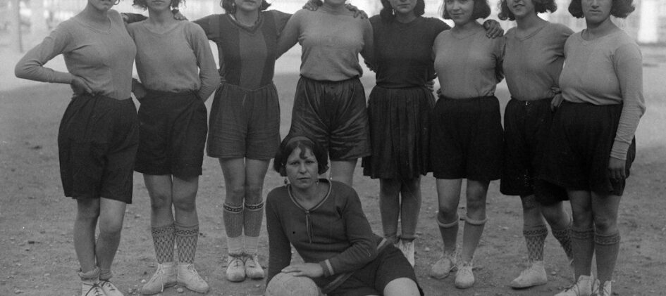 Historische Frauenfußballmannschaft mit Ball auf einem Spielfeld