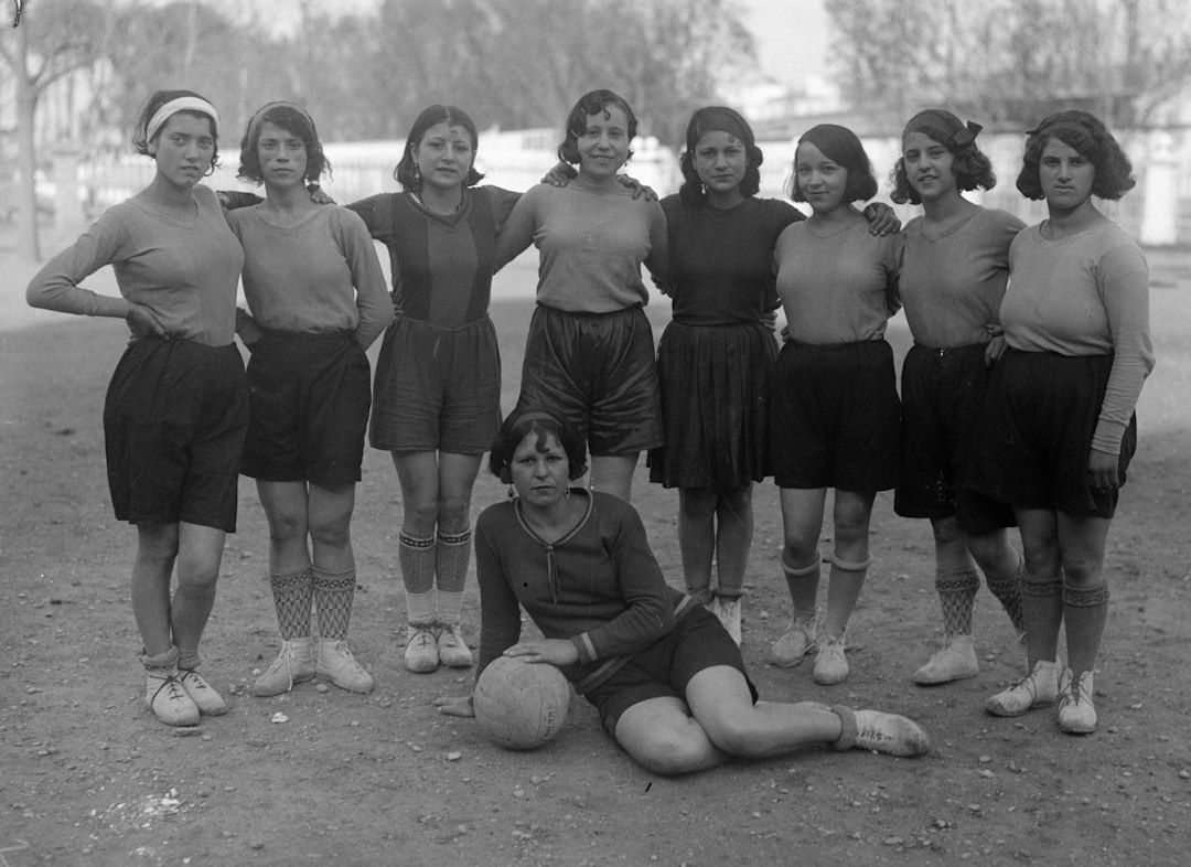 Historische Frauenfußballmannschaft mit Ball auf einem Spielfeld